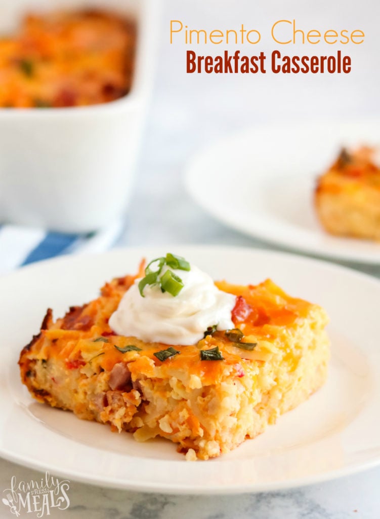 Pimento Cheese Breakfast Casserole - a piece of breakfast casserole on a white plate, topped with a dolip of sour cream and sliced green onions - words on the upper right saying pimento cheese breakfast casserole.jpg