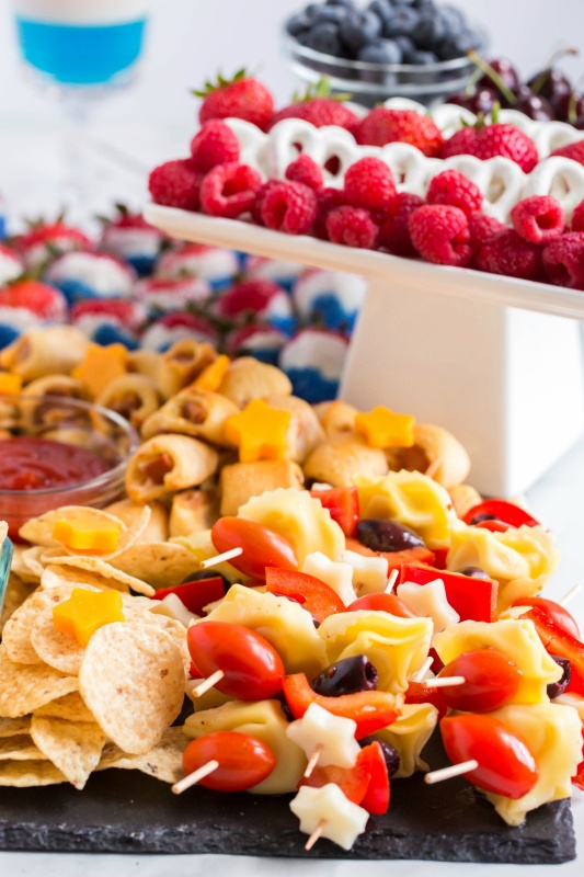 close up image of pasta, tomato, cheese and olive kabobs on the 4th of July Snack Board