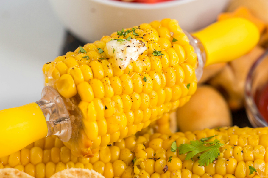 close up image of small piece of corn on the cob with melted butter on it