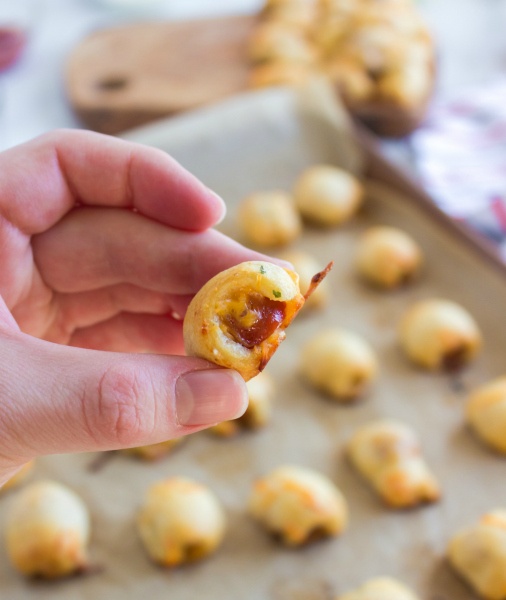 a hand holding a cheddar ranch hotdog nugget