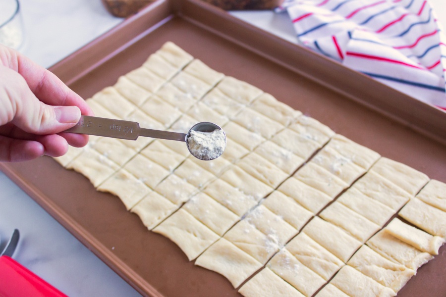 sprinkling ranch seasoning over small dough squares