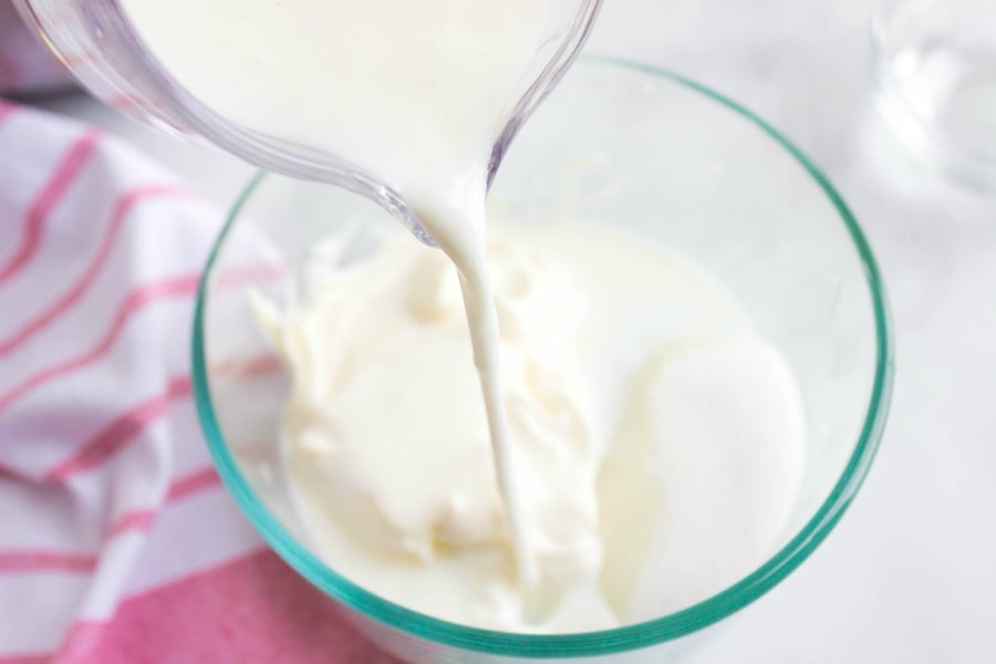  milk being poured into glass bowl with mayo