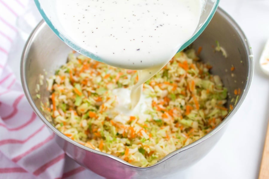 pouring mayo, milk mixture into bowl with diced cabbage and carrot