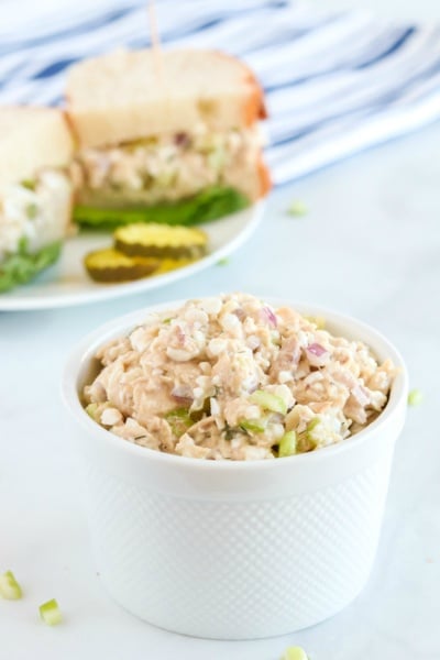 Cottage Cheese Tuna Salad in a small white bowl, with a sandwich in the background