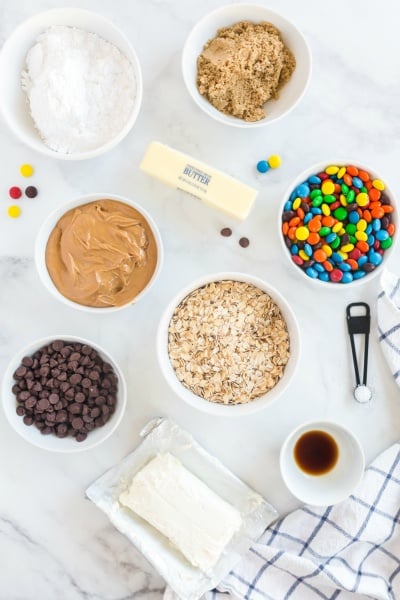 ingredients for recipe in small white bowls, a stick of better and a block of cream cheese