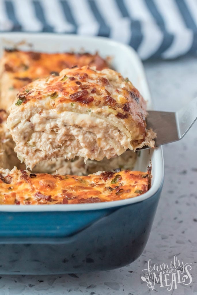 Scooping out a piece crack chicken lasagna with a spatula