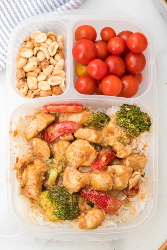 Easy Thai Peanut Chicken leftovers in a lunch box with cherry tomatoes and peanuts
