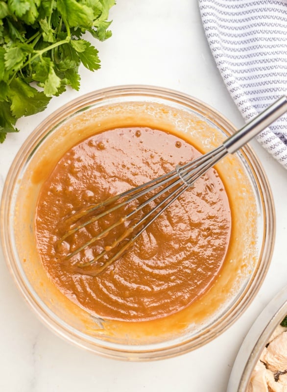 Mixing bowl with peanut sauce in a bowl with a whisk