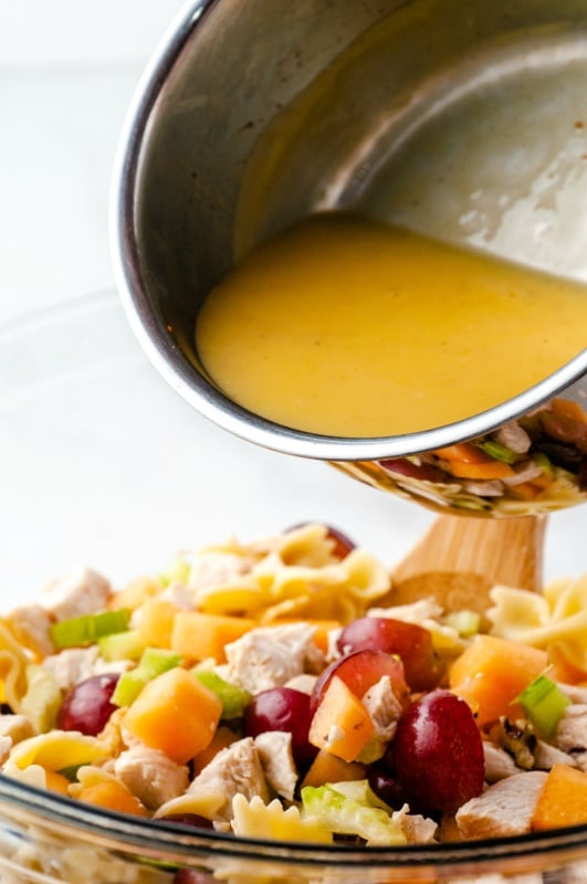 pouring dressing over chicken salad