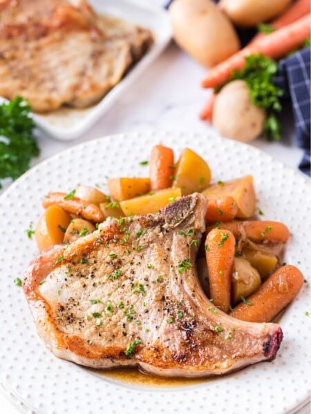Instant Pot Pork Chops with potatoes and Carrots - served on a white plate