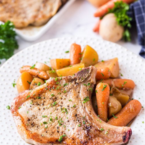 Instant Pot Pork Chops with potatoes and Carrots - served on a white plate