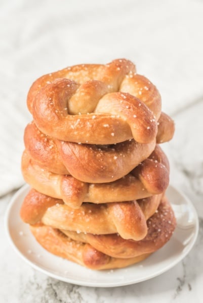 Stack of homemade soft pretzels on a white plate