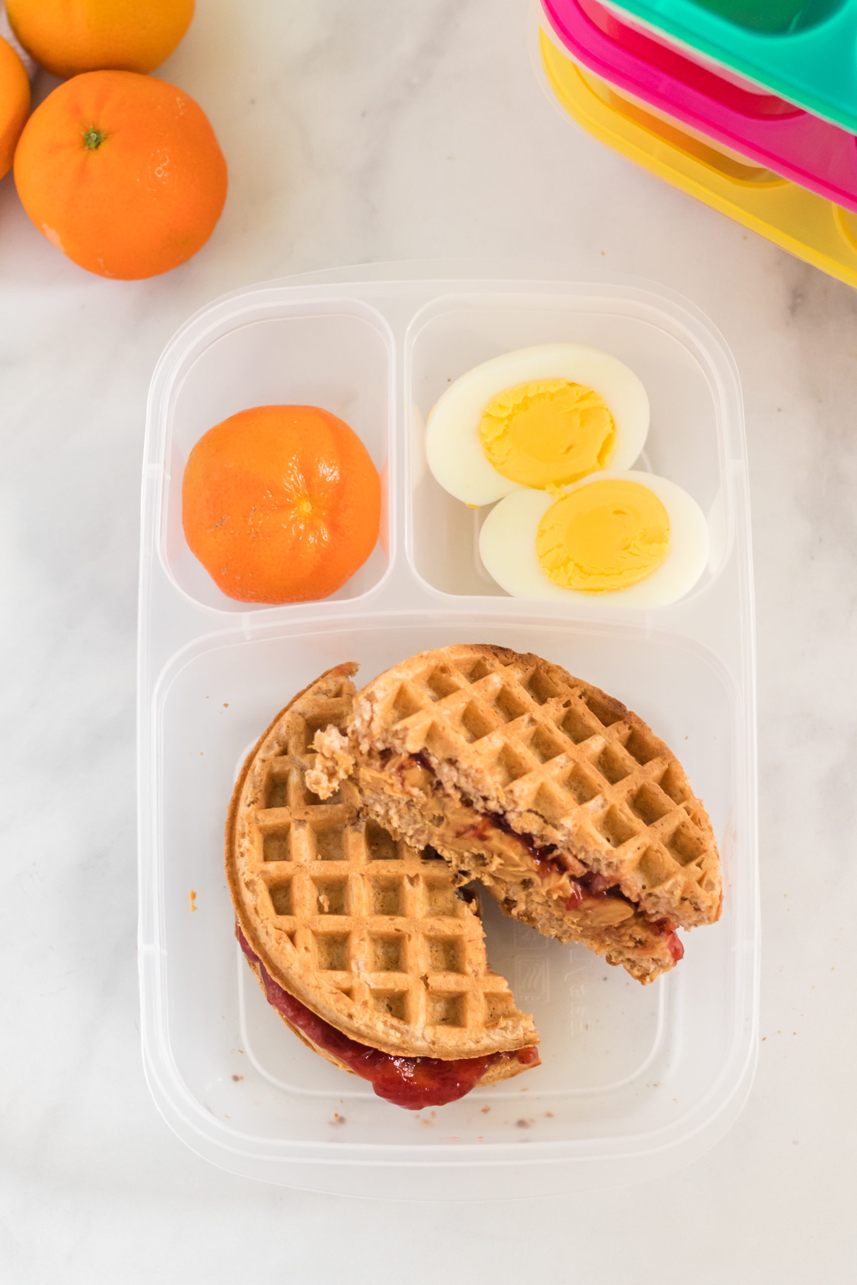 PBJ Waffle Sandwich packed in lunchbox with an orange and hard boiled egg via @familyfresh