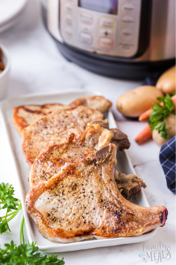 cooked pork chops on a white platter