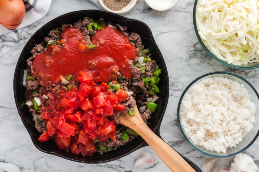 tomatoes and tomato sauce being added to pan