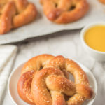 two soft pretzels on a white plate