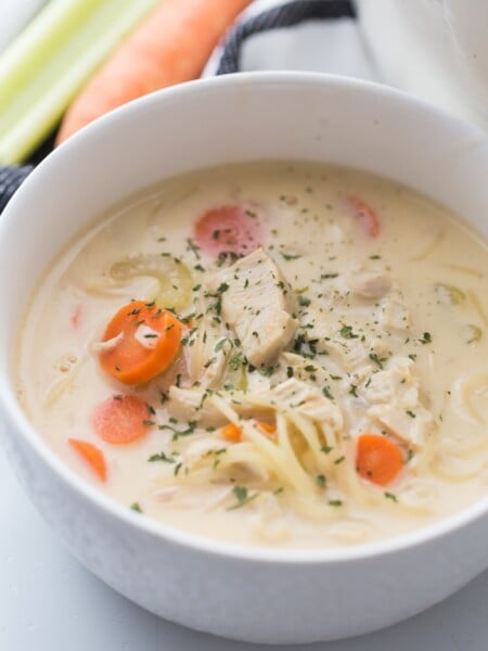Creamy chicken noodle soup in a white bowl