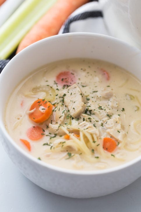 Creamy chicken noodle soup in a white bowl