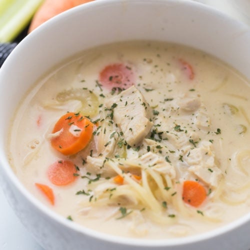 Creamy chicken noodle soup in a white bowl