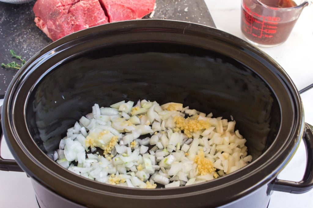 diced onions and garlic in a slow cooker