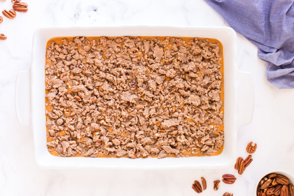 top down image of crumble placed on top of cake before baking