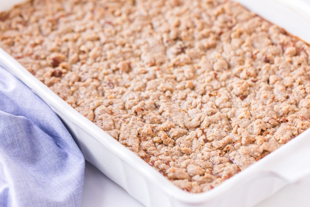 angled photo of cooked pumpkin dump cake in white baking dish