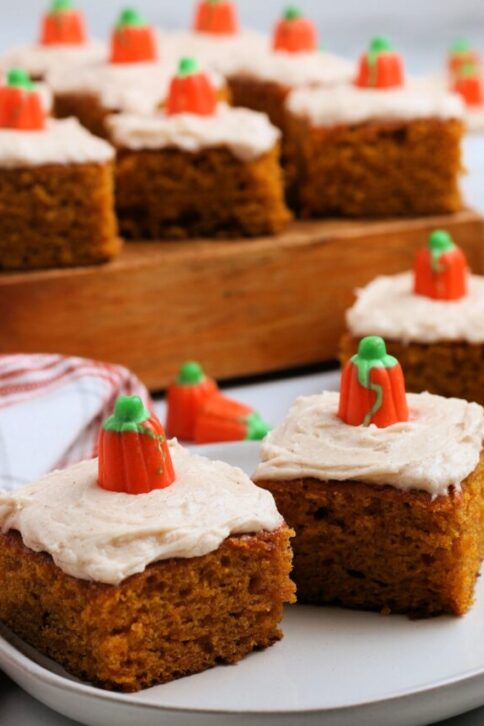 several pumpkin bars on a plate and on a wooden board