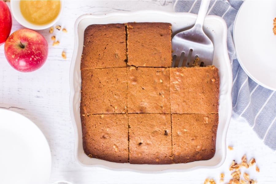 applesauce cake in baking dish with a piece removed