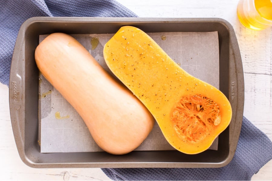 butternut squash cut in half in a baking pan