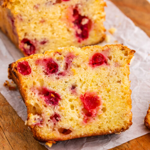 Cranberry Orange bread on a cutting board with one slice cut off