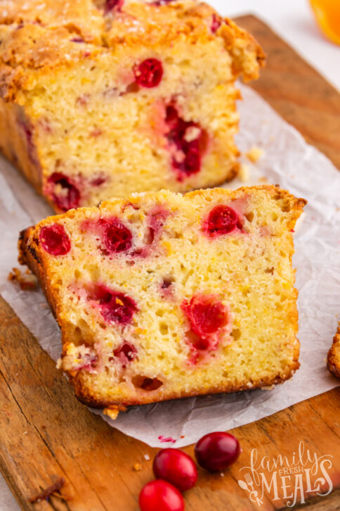 Cranberry Orange bread on a cutting board with one slice cut off