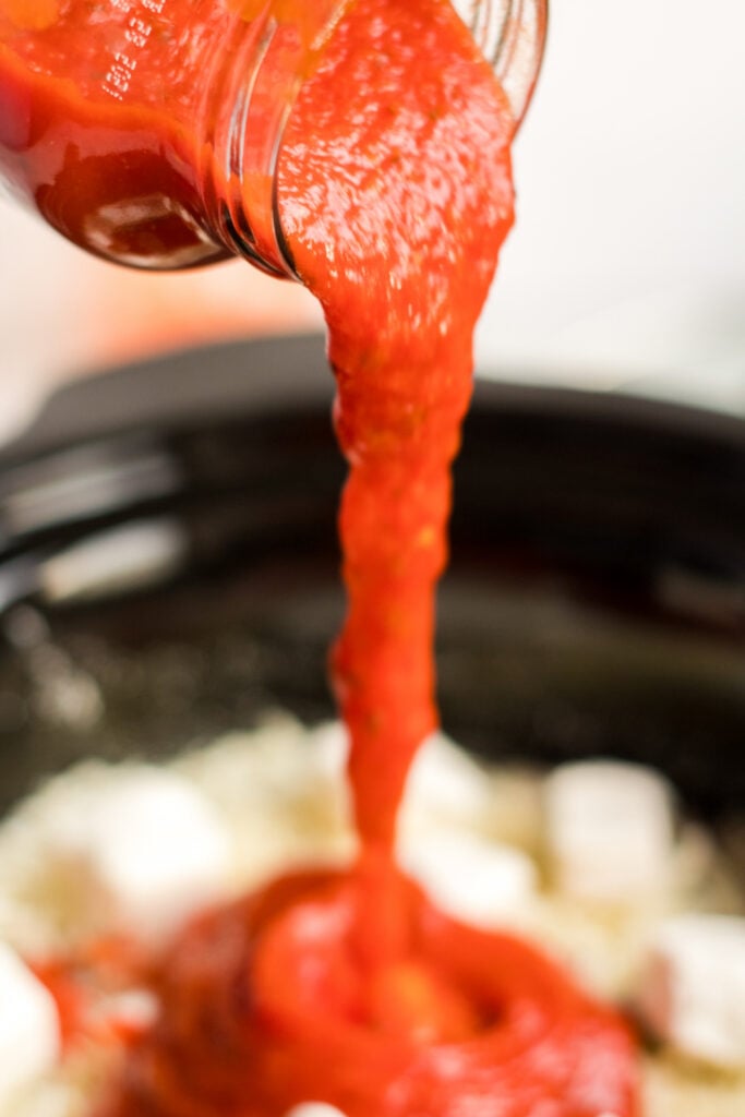 pouring sauce into slow cooker