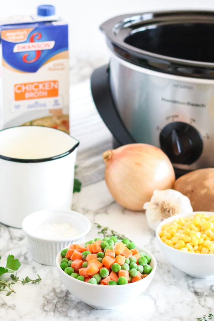 Ingredients for pot pie soup sitting in front of slow cooker