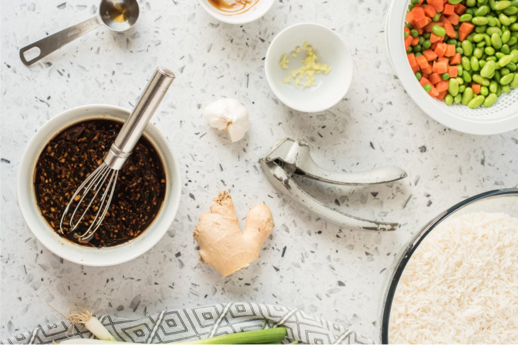 soy sauce, oyster flavored sauce, 1 tablespoon sesame oil, garlic, and ginger being mixed in a small mixing bowl