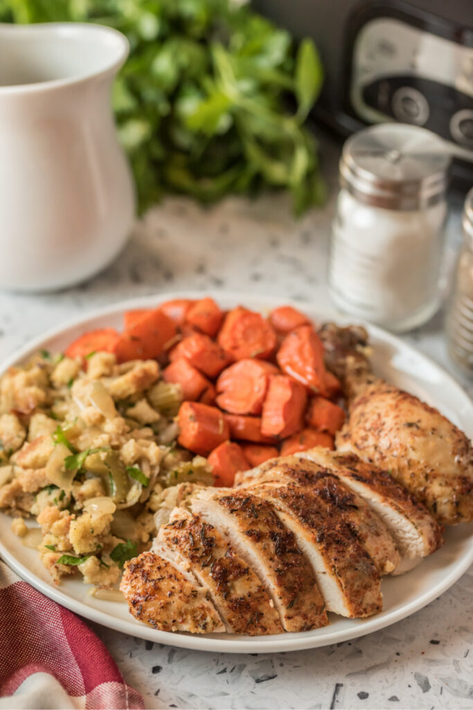 sliced chicken, stuffing and carrots on a plate