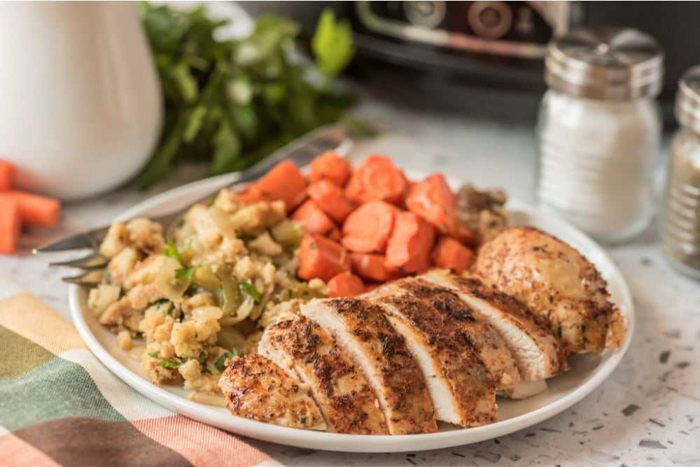 sliced chicken, stuffing and carrots on a plate