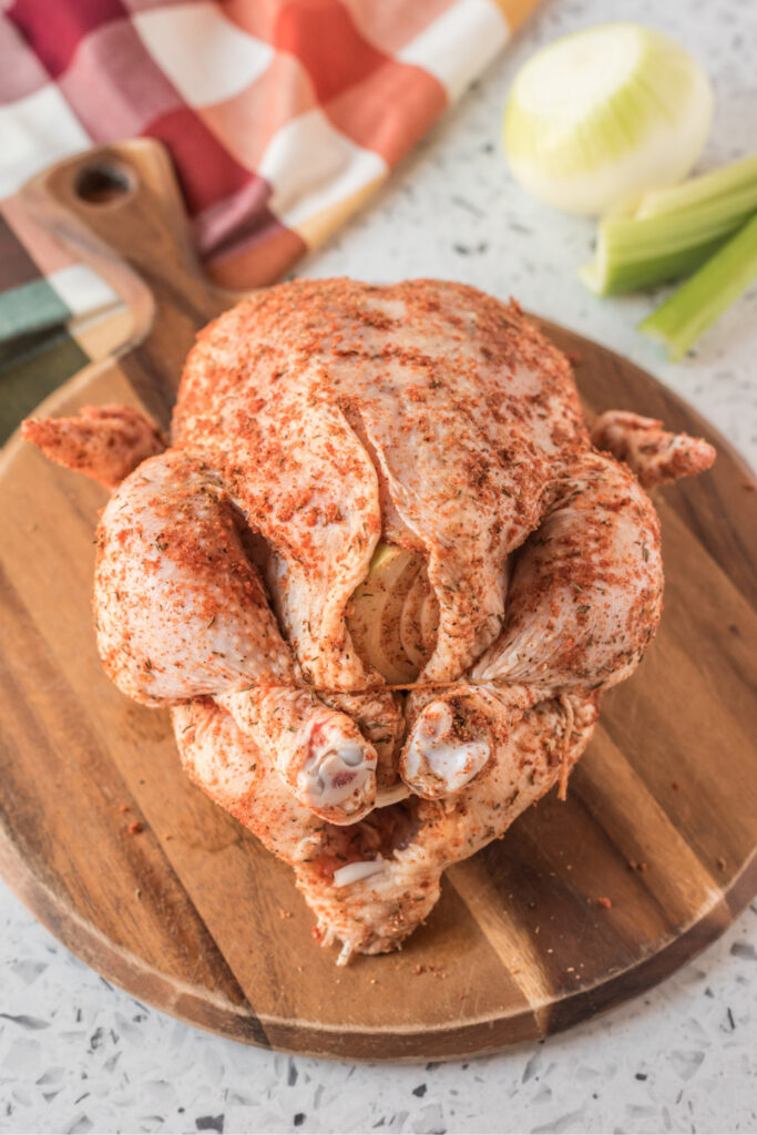 Whole chicken with seasoning rub, on a cutting board