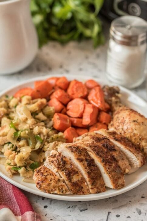 sliced chicken, stuffing and carrots on a plate