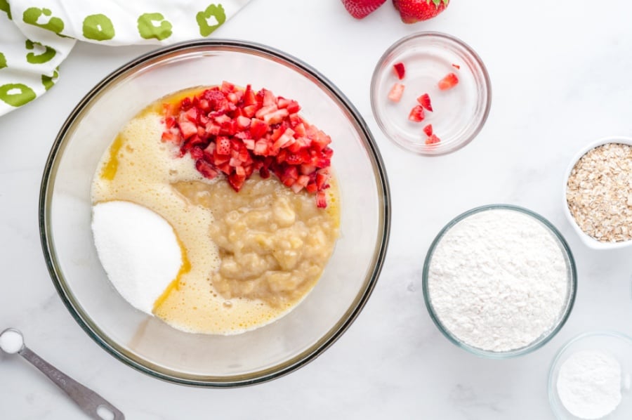 butter, sugar, strawberries and mashed bananas in a mixing bowl