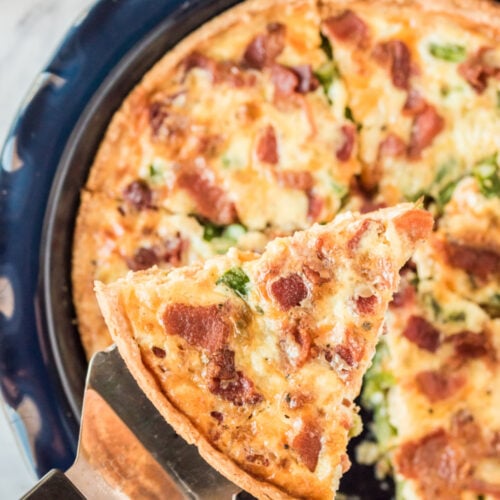 Asparagus Bacon Quiche with a piece being taken from pan