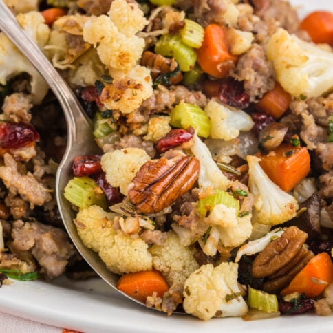 Savory cauliflower stuffing on a platter with a serving spoon