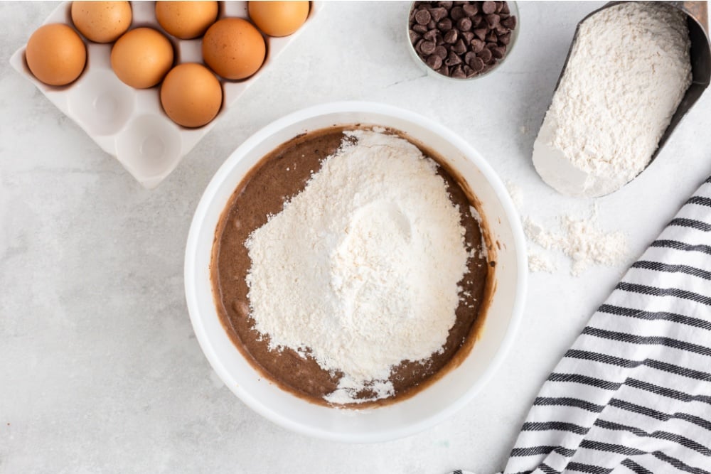 flour and baking soda being added to mixing bowl