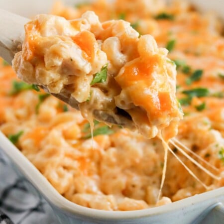 Spoon scooping out some mac and cheese from a baking dish