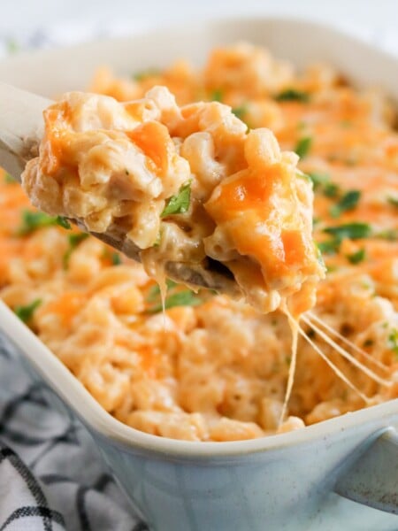 Spoon scooping out some mac and cheese from a baking dish