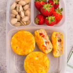 Lunchbox packed with egg cups, strawberries and pistachios