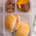 lunchbox packed with 2 mini turkey sliders, sweet potatoes and pecans