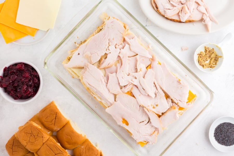 adding leftover turkey on top of cheese