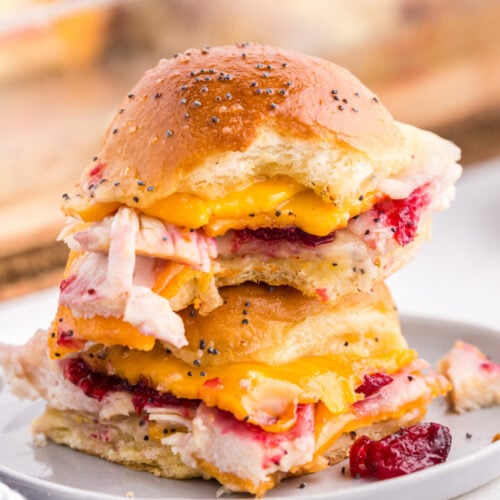 Two leftover Thanksgiving sliders stacked on top of each other, on a plate