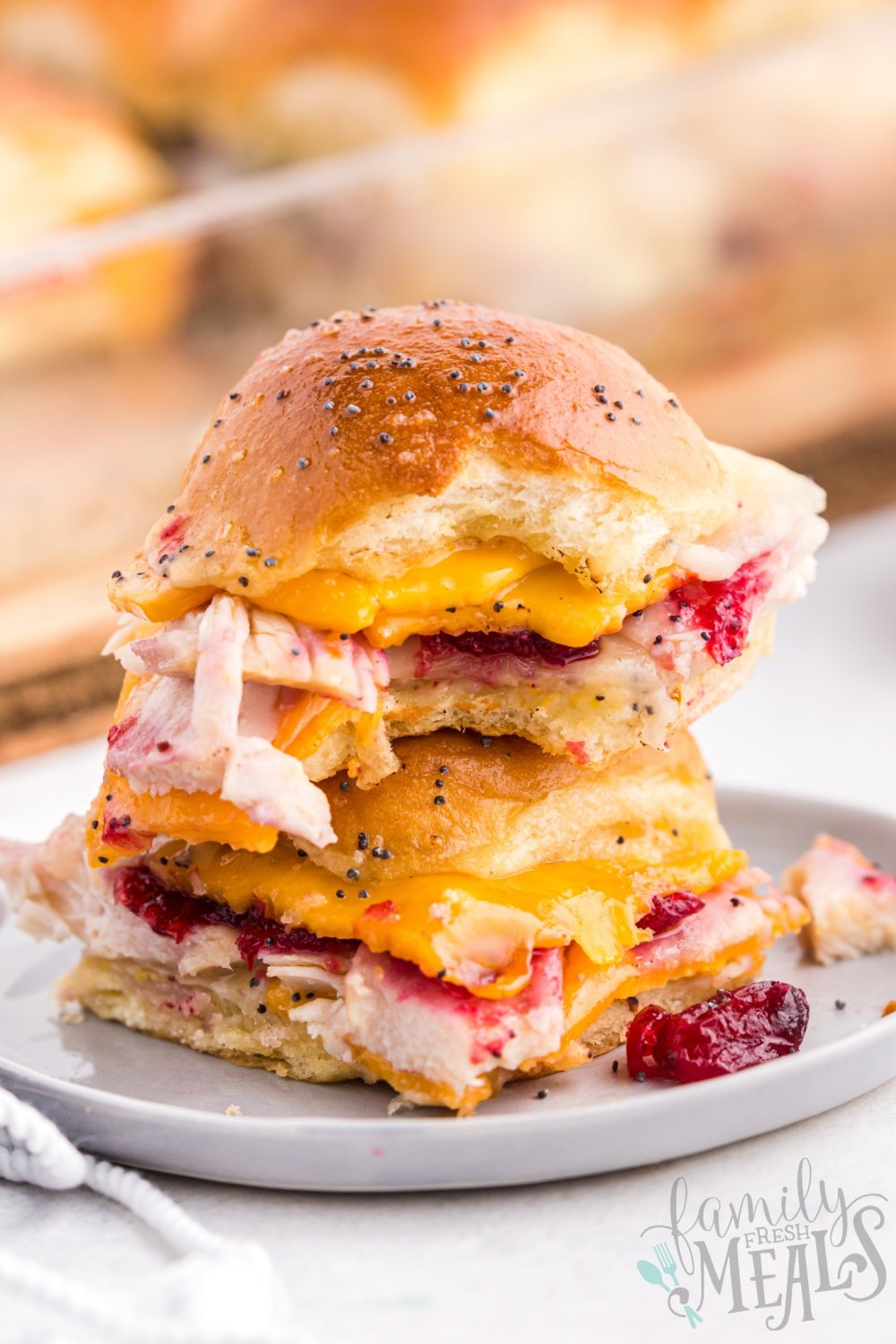 Two leftover Thanksgiving sliders stacked on top of each other, on a plate