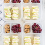 4 lunchboxes packed with Mini Cucumber Sandwiches, cookies and grapes